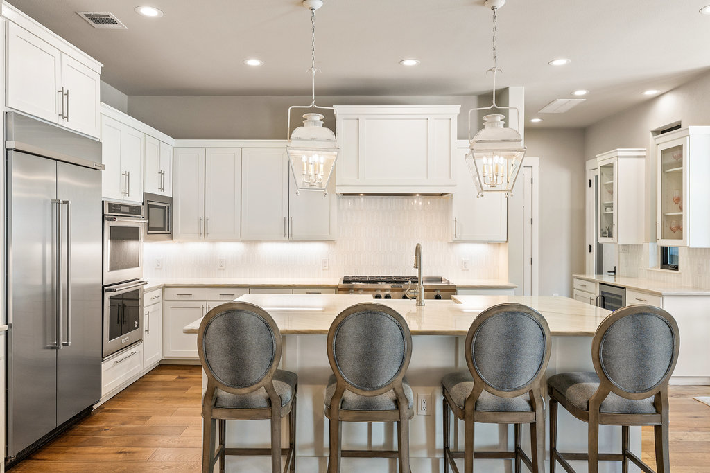 4746 R O Drive Spicewood, TX 78669 - Photo 16 of 40 a kitchen with refrigerator cabinets dining table and chairs