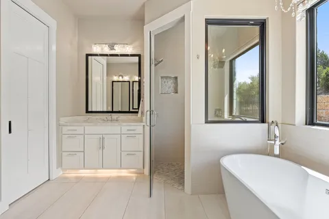 a bathroom with a bathtub a mirror and a sink