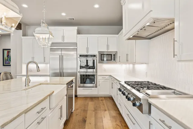 a kitchen with stainless steel appliances granite countertop a sink stove and refrigerator