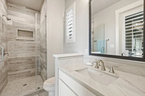 a bathroom with a granite countertop sink toilet and shower
