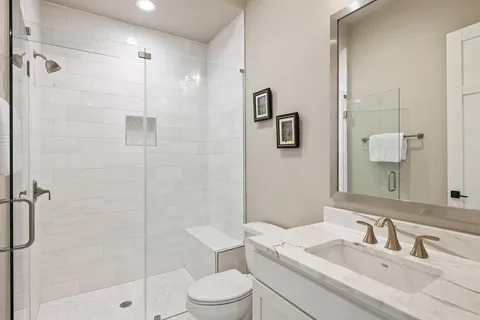 a bathroom with a sink a toilet and shower