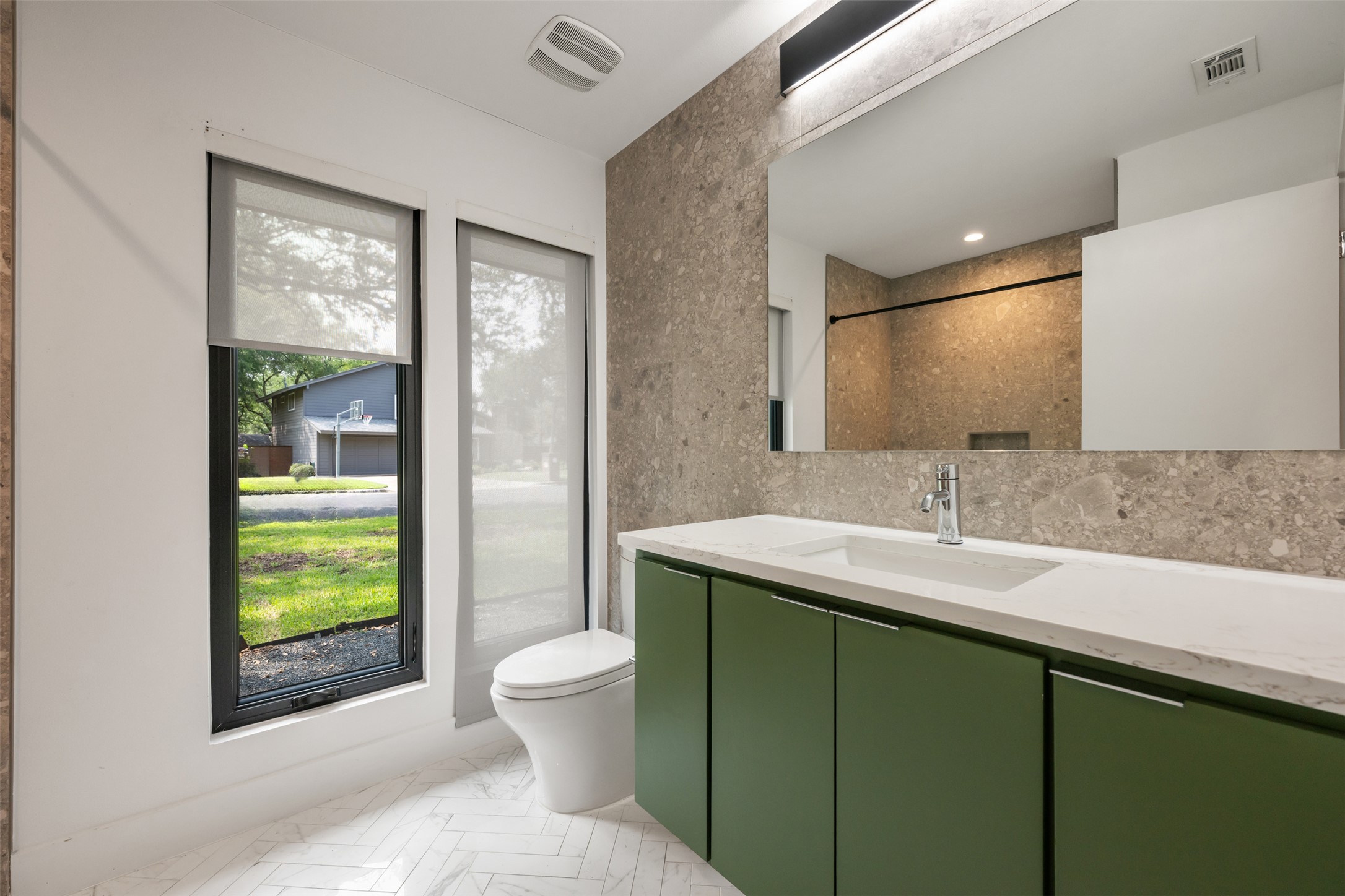 8900 Point W Drive Austin, TX 78759 - Photo 34 of 40 A well-lit bathroom features modern design with a unique green vanity and textured tile accent wall.