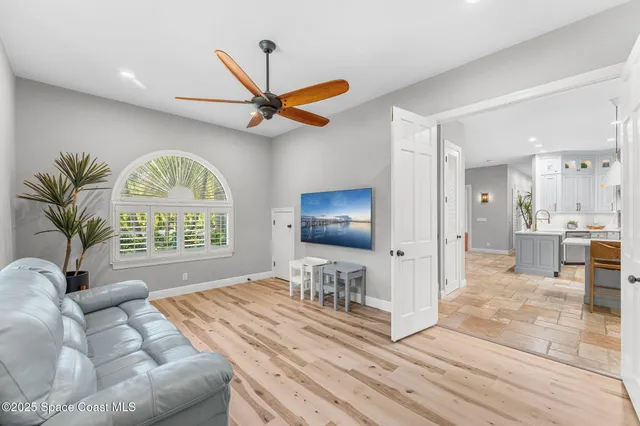 a living room with furniture a flat screen tv and a chandelier