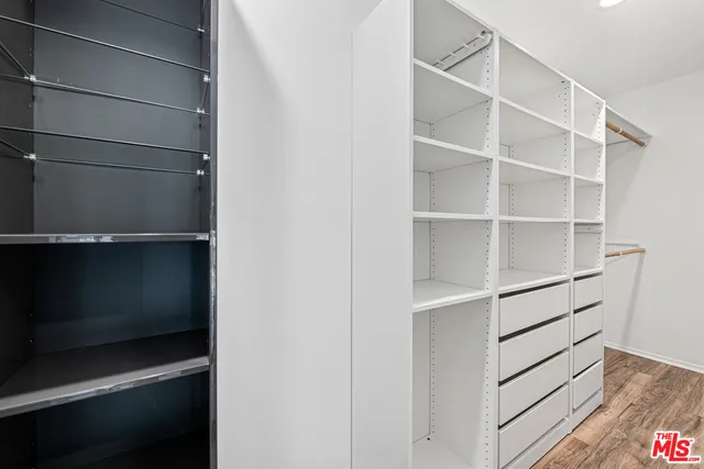 a view of walk in closet with empty racks