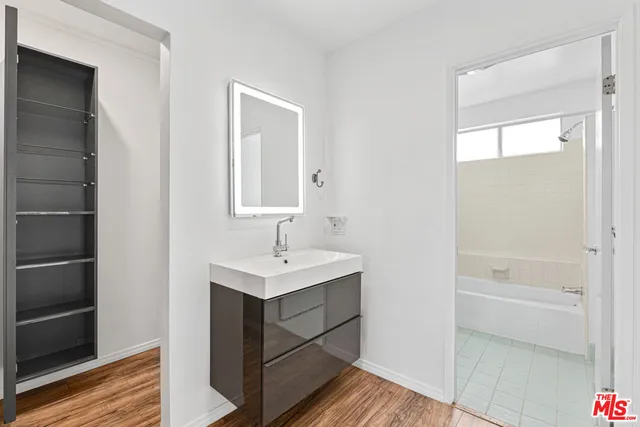 a bathroom with a sink a shower and a mirror