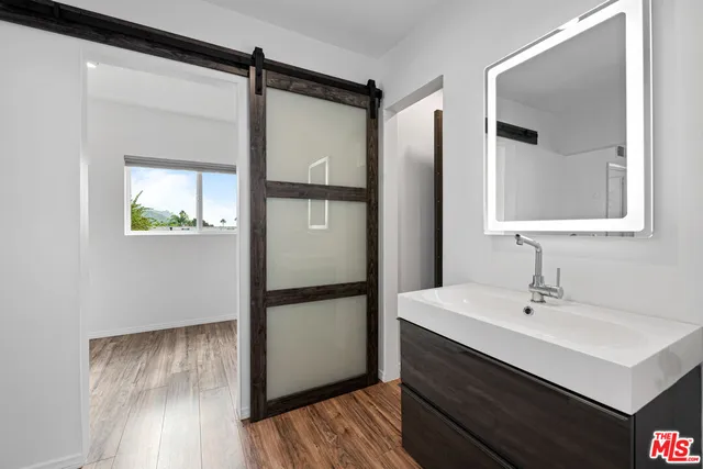 a bathroom with a sink mirror and a shower