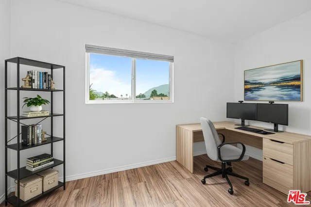 a view of a workspace with furniture and wooden floor