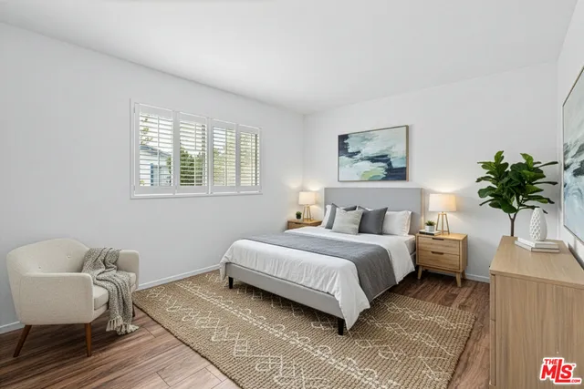 a spacious bedroom with a bed a couch and a potted plant