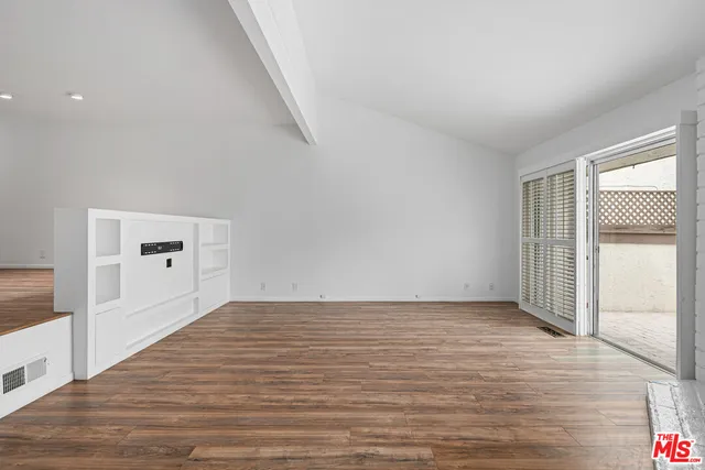 a view of a livingroom with wooden floor and a ceiling fan
