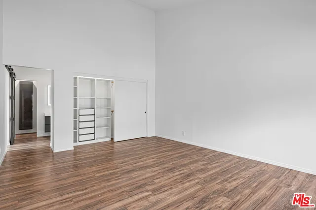 a view of an empty room with wooden floor
