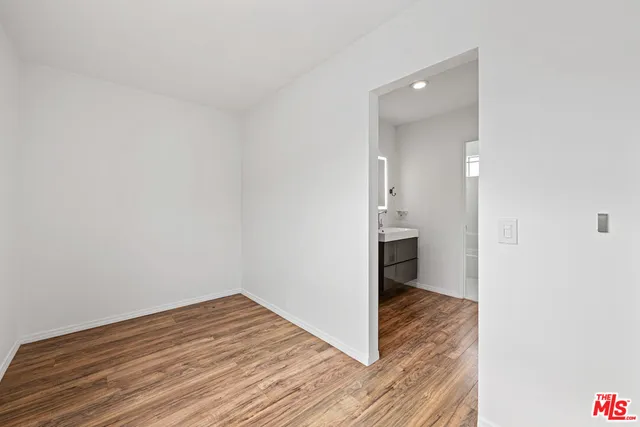 a view of a hallway view with wooden floor and a bathroom