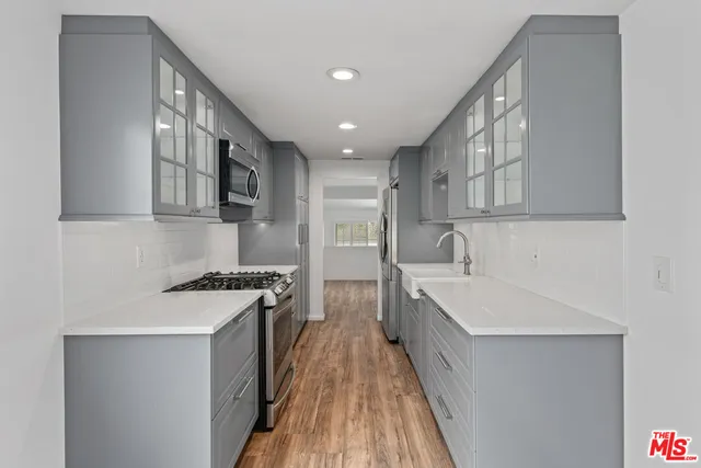 a kitchen with stainless steel appliances granite countertop a sink stove and refrigerator