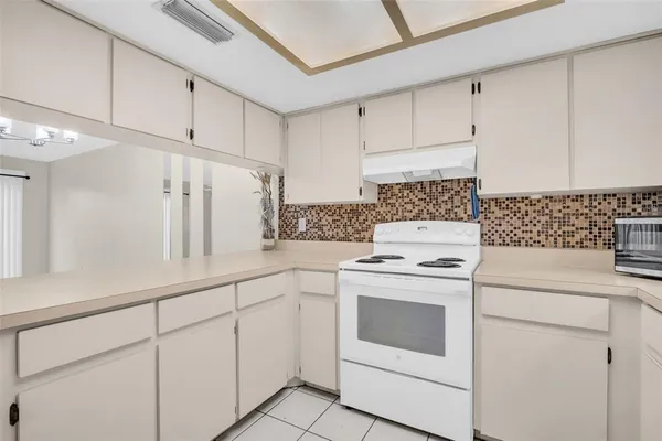 a kitchen with white cabinets and white appliances