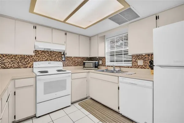a kitchen with white cabinets sink and white appliances