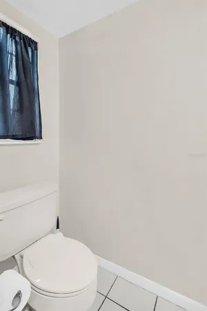 a white toilet sitting next to a shower