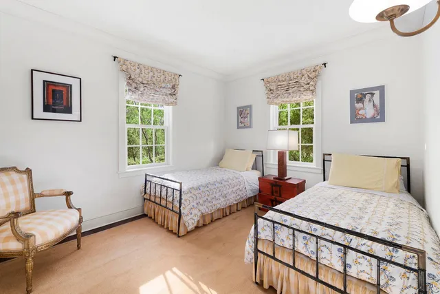 a bedroom with two beds and a window