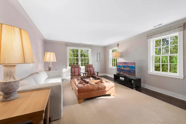 a living room with furniture and a flat screen tv with wooden floor