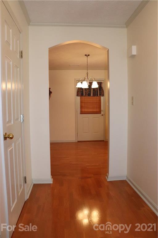 4120 Lower Cedar Valley Road Hudson, NC 28638 - Photo 17 of 48 an empty room with wooden floor and chandelier