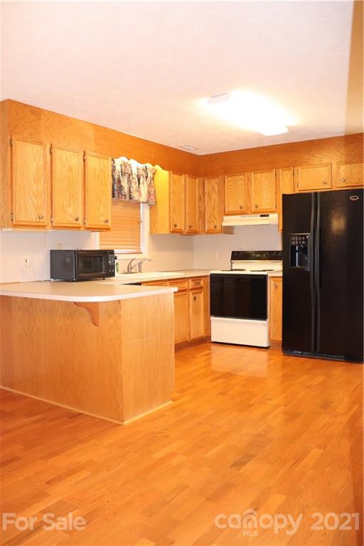 4120 Lower Cedar Valley Road Hudson, NC 28638 - Photo 10 of 48 a kitchen with stainless steel appliances granite countertop a refrigerator and a stove top oven