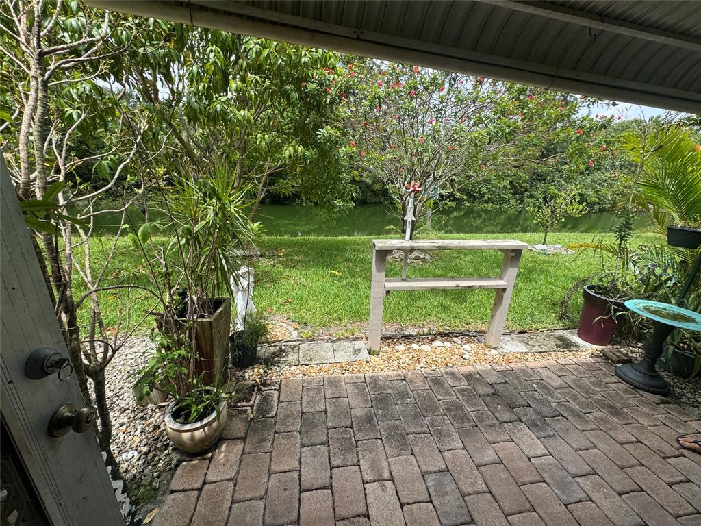61 Camden C, Unit C West Palm Beach, FL 33417 - Photo 20 of 23 a view of a yard with plants and a table chair