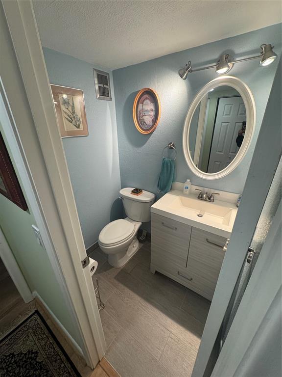 61 Camden C, Unit C West Palm Beach, FL 33417 - Photo 3 of 23 a bathroom with a toilet a sink and mirror