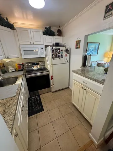 a kitchen with a stove a refrigerator and cabinets