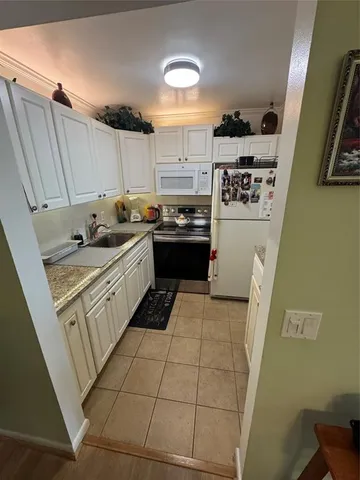 a kitchen with a sink a stove and cabinets