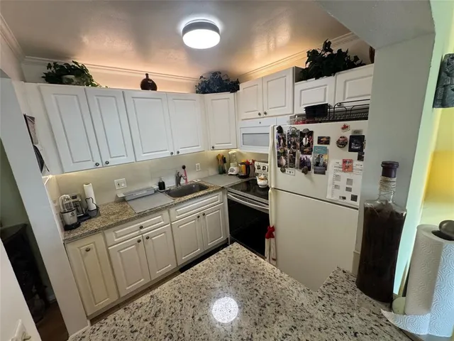 a kitchen with stainless steel appliances granite countertop a refrigerator sink and cabinets