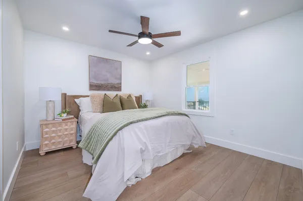 a bedroom with a bed and a ceiling fan
