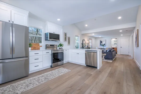 a kitchen with white cabinets and stainless steel appliances