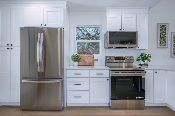 a kitchen with appliances a microwave and cabinets