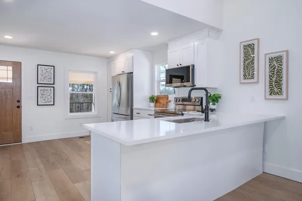 a kitchen with stainless steel appliances a sink stove and microwave