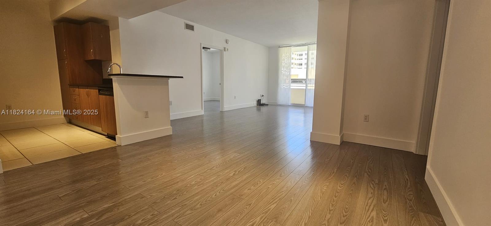 2775 Northeast 187th Street, Unit 424 Aventura, FL 33180 - Photo 5 of 16 a view of a kitchen with wooden floor and a refrigerator