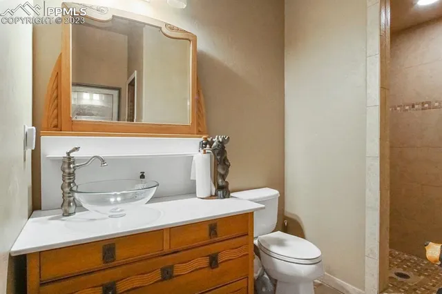 a bathroom with a granite countertop sink mirror vanity and toilet