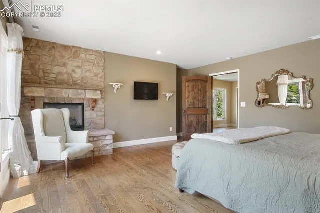 a spacious bedroom with a bed and wooden floor