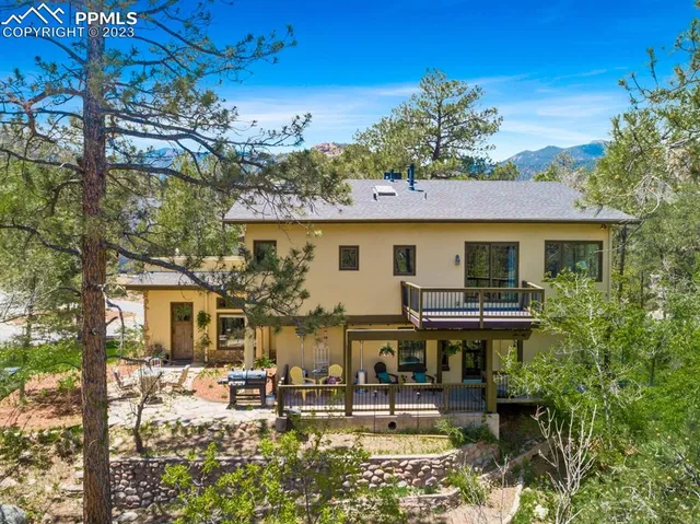 a front view of house with yard outdoor seating and covered with trees