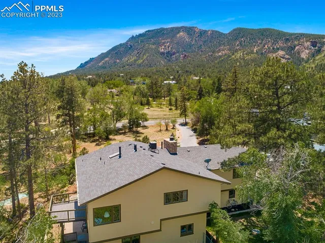 an aerial view of residential houses with outdoor space and trees