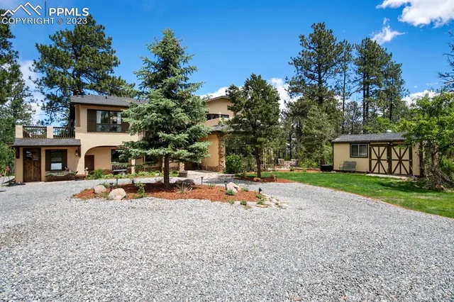 a view of a house with backyard and sitting area