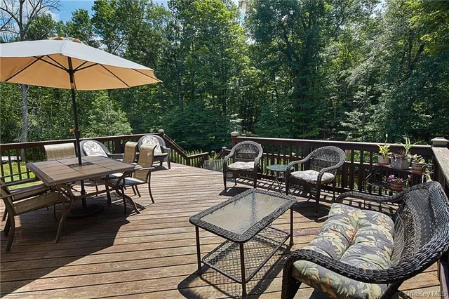 a view of a roof deck with table and chairs under an umbrella