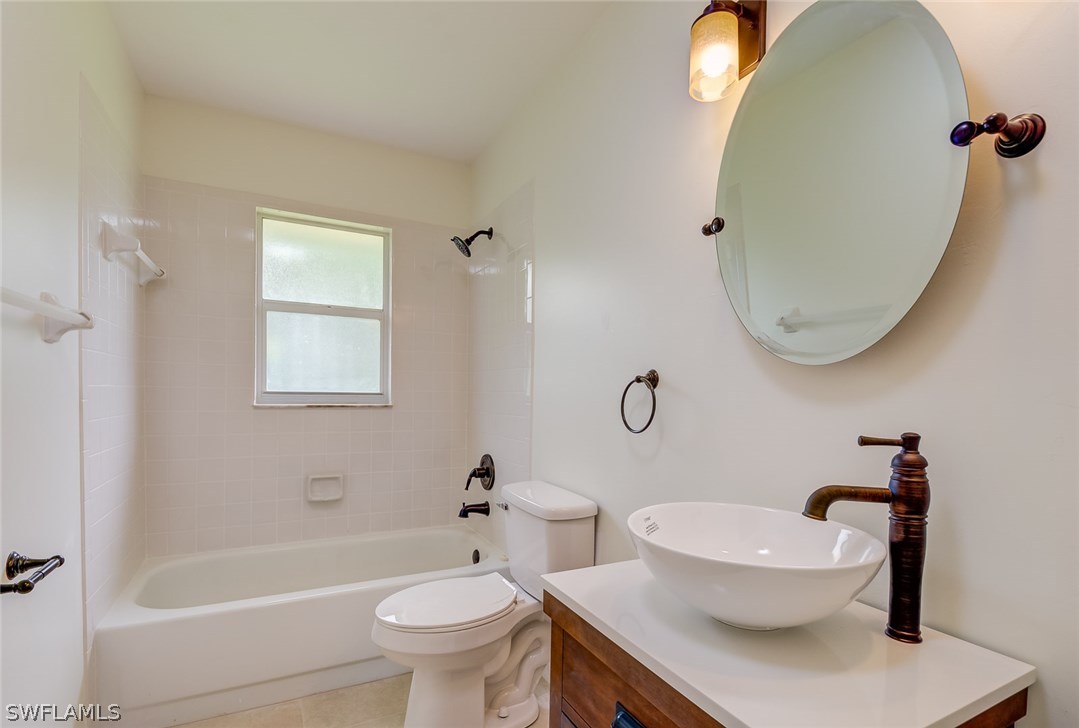 7232 Coolidge Road Fort Myers, FL 33967 - Photo 17 of 25 a white toilet sitting next to a bathroom sink and tub