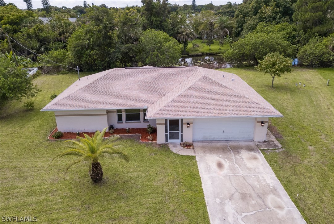 7232 Coolidge Road Fort Myers, FL 33967 - Photo 22 of 25 a view of a house with pool yard and a lawn chairs under an umbrella