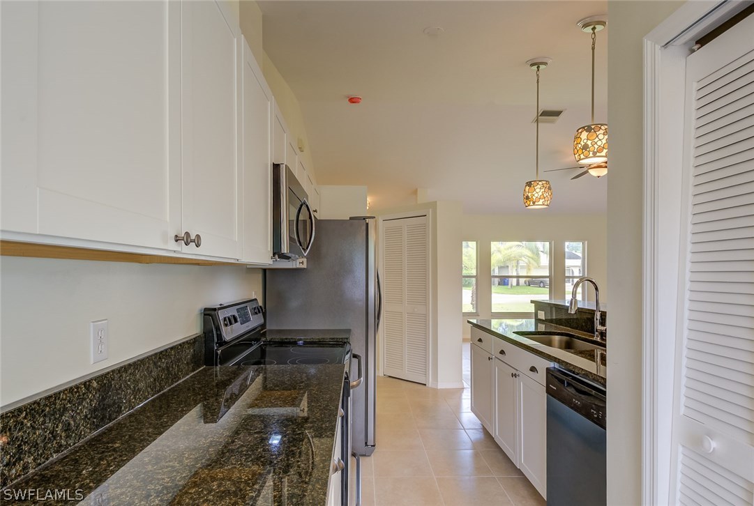 7232 Coolidge Road Fort Myers, FL 33967 - Photo 5 of 25 a kitchen with a sink and stainless steel appliances