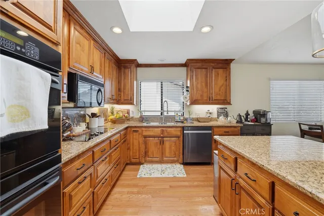 a large kitchen with stainless steel appliances granite countertop a stove and a sink