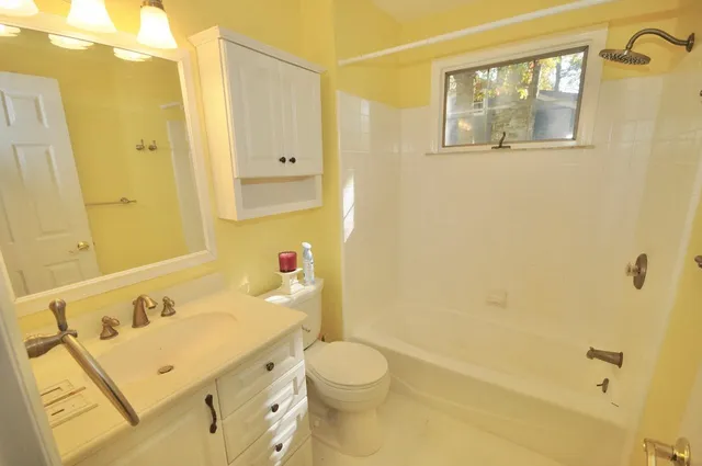 a bathroom with a granite countertop sink toilet and shower