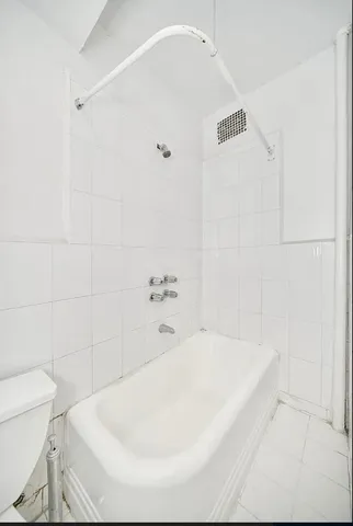 a white bath tub sitting next to a white toilet