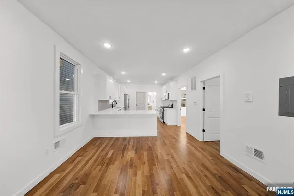 a large kitchen with cabinets wooden floor and stainless steel appliances