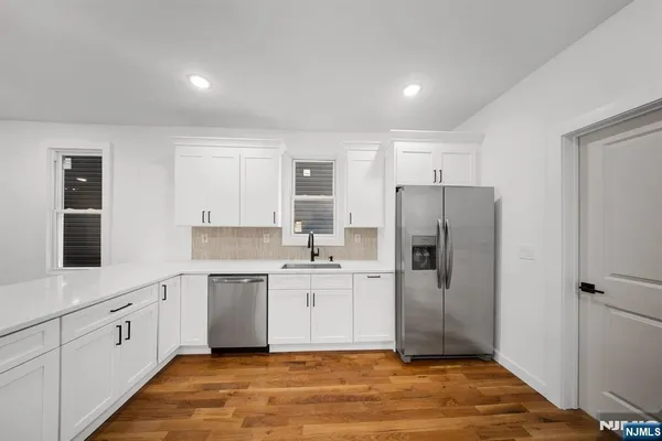 a view of a room with wooden floor and white walls
