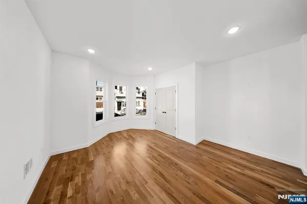 a view of a room with wooden floor and white walls