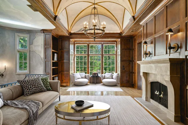 a living room with furniture a fireplace and a chandelier