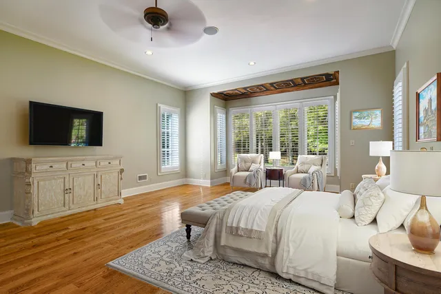 a spacious bedroom with a bed and a flat screen television